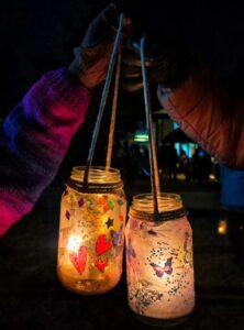 hanging decorated mason jars illuminated from inside by candles
