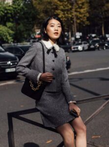 a woman wearing a houndstooth blazer and skirt set