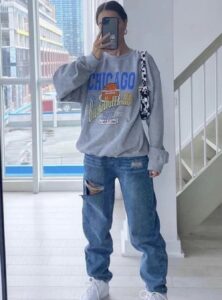 woman wearing a gray oversize sweatshirt and jeans