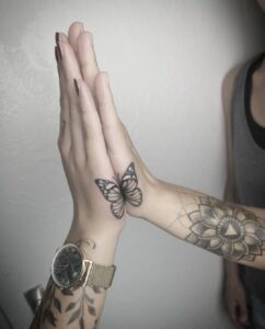 matching tattoo half butterfly on hands